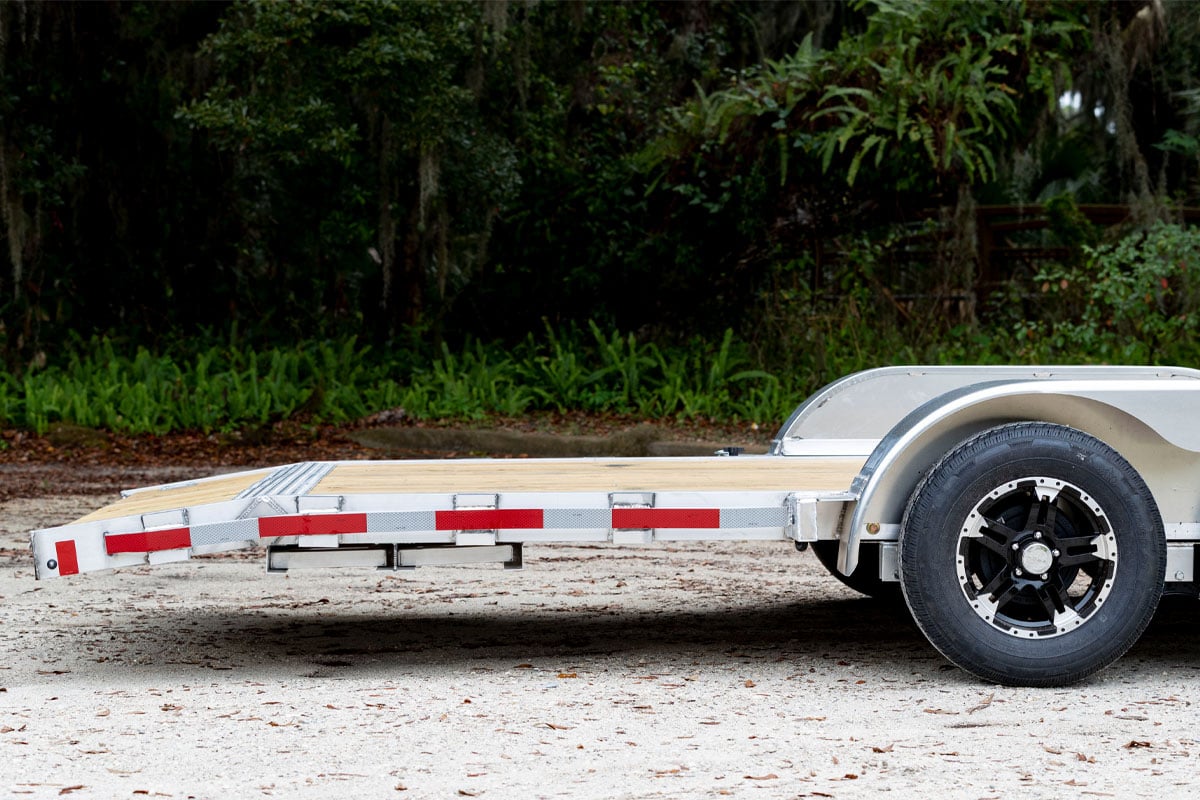 Open wood deck car trailer from ALCOM with a two-foot beavertail 