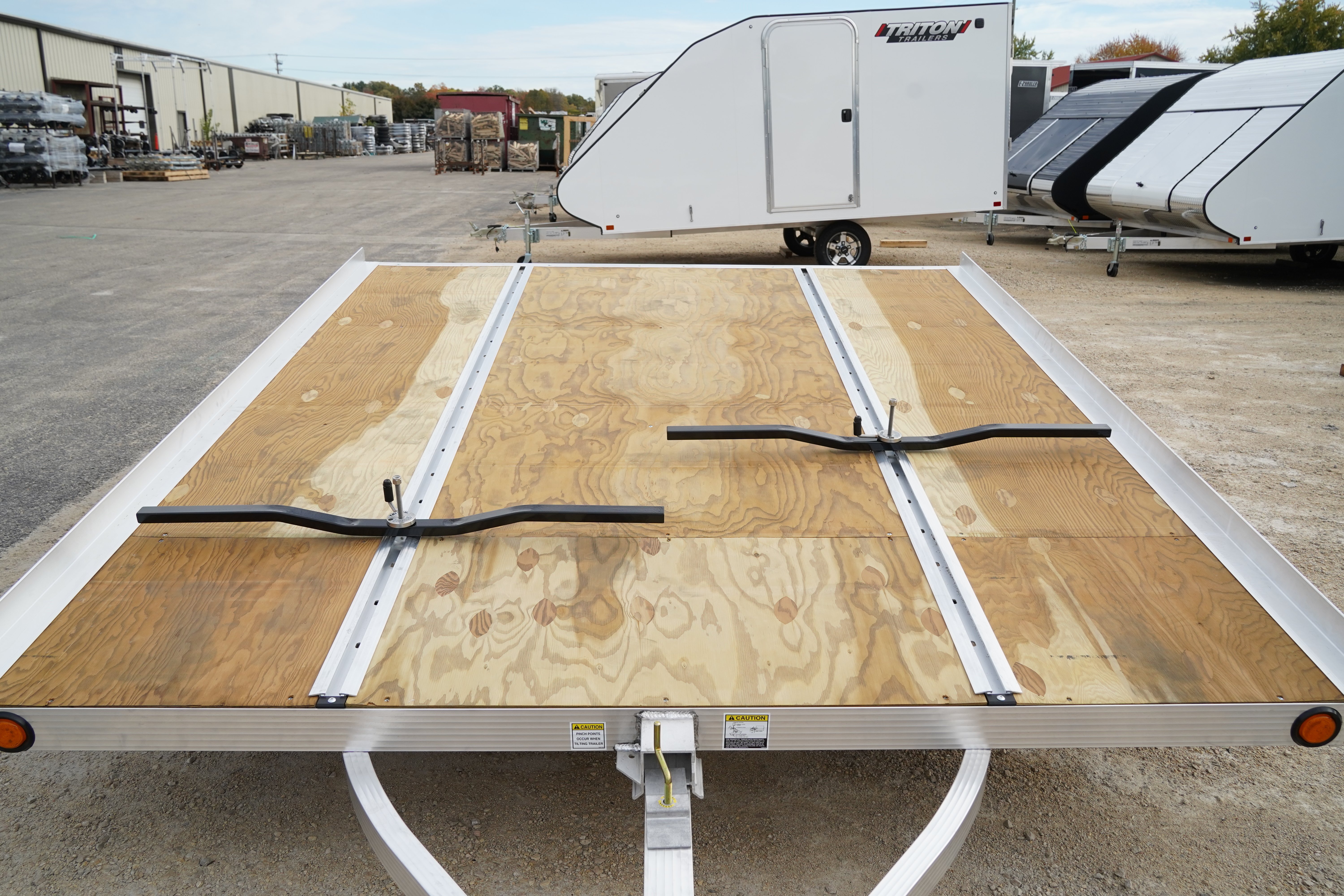 Open snowmobile trailer with slide track and tie-down bars