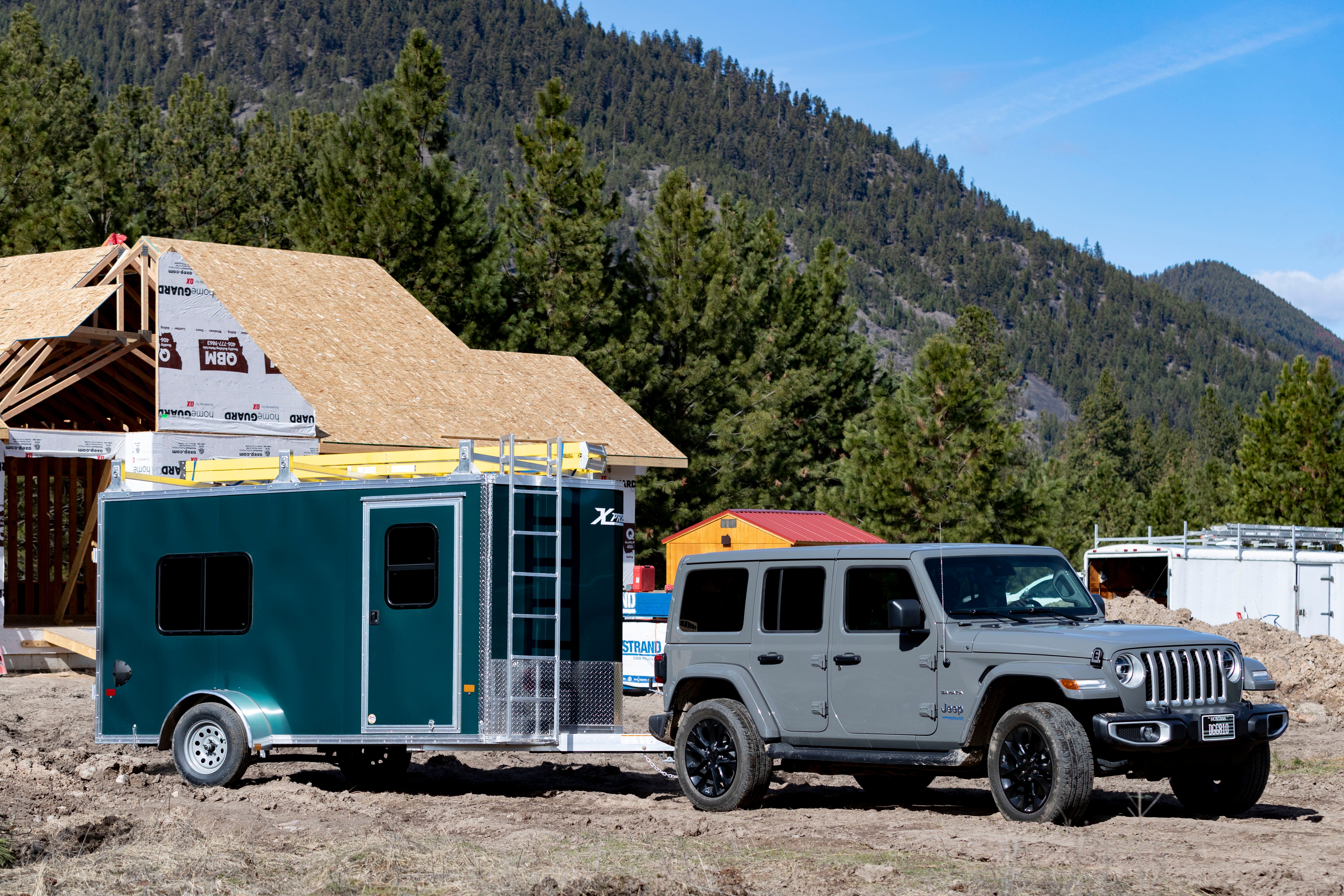 An enclosed contractor package with ladder racks parked at a residential jobsite