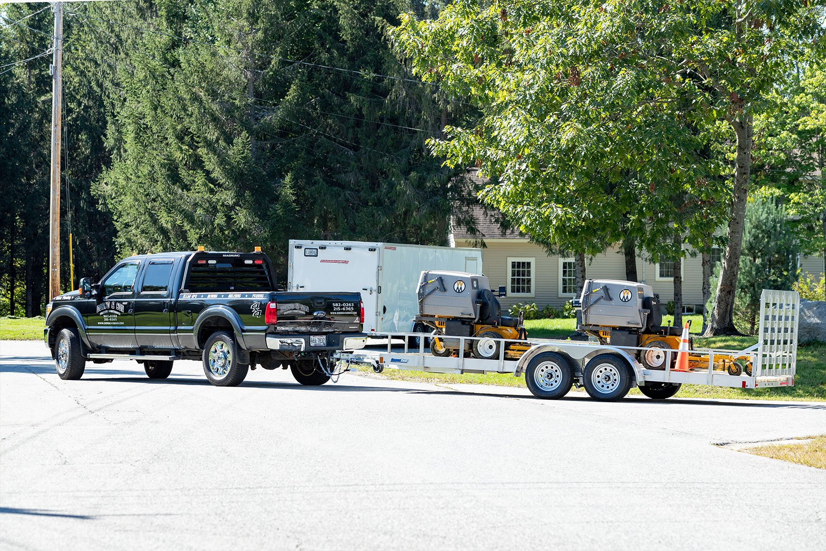 Open and enclosed aluminum landscape trailers from ALCOM on the jobsite