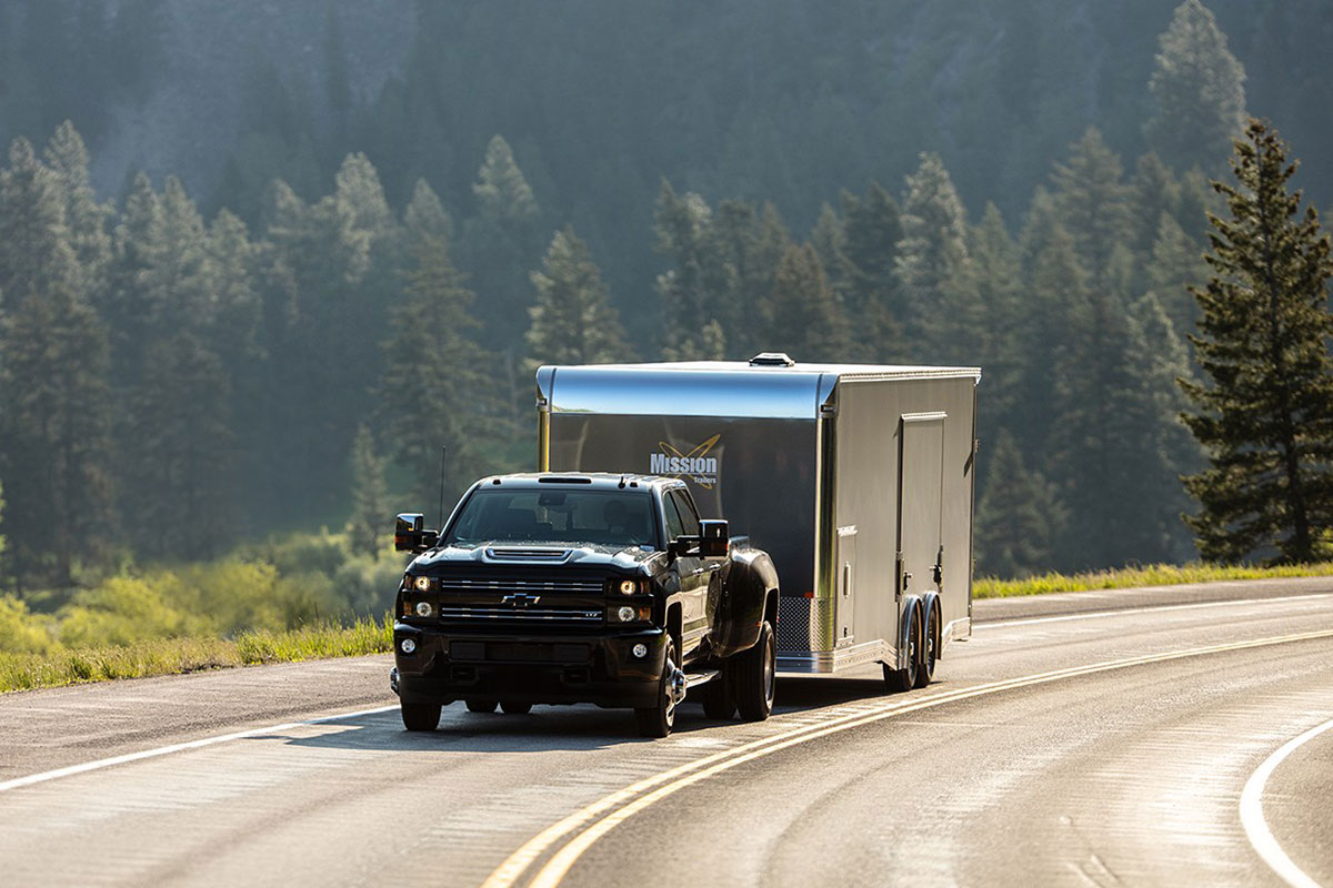 Pickup truck hauling a tandem axle ALCOM car hauler with braked axles