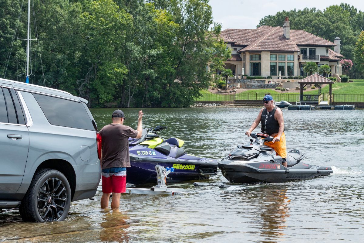 2 place PWC trailer with skiers loading on the boat ramp