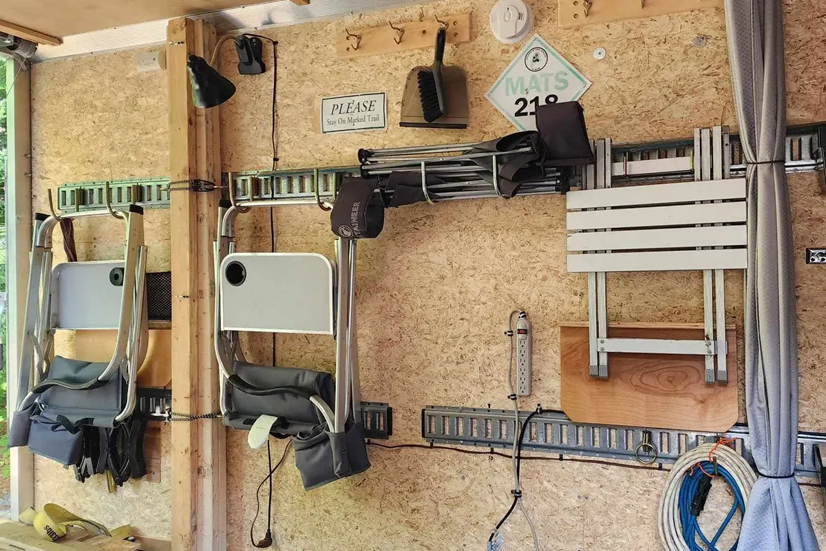 Inside the ALCOM camper trailer with interior wall hooks, tracks, and storage