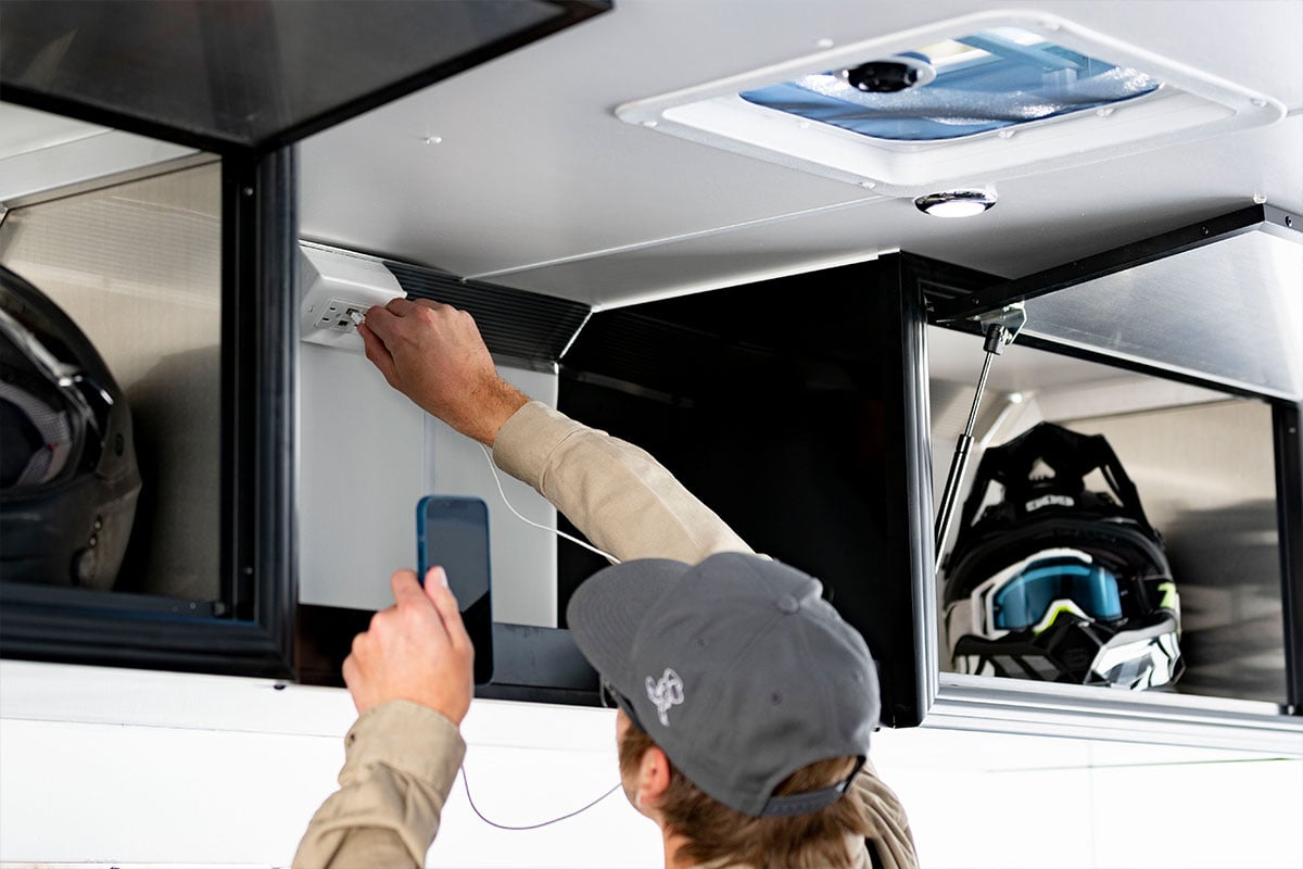 Power package options showing roof vent and a man using wall outlets with USB receptacles.