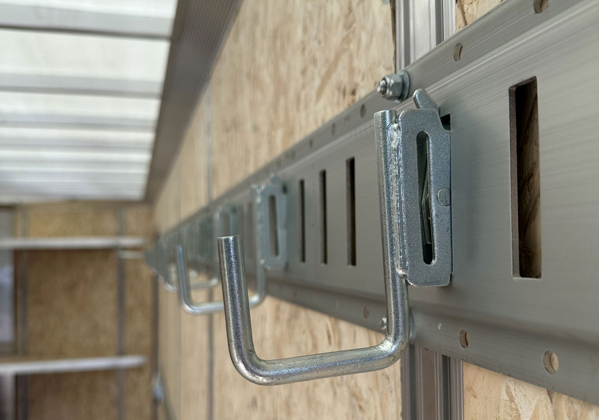 E-track attached to wall studs with wall hooks attached to E-track
