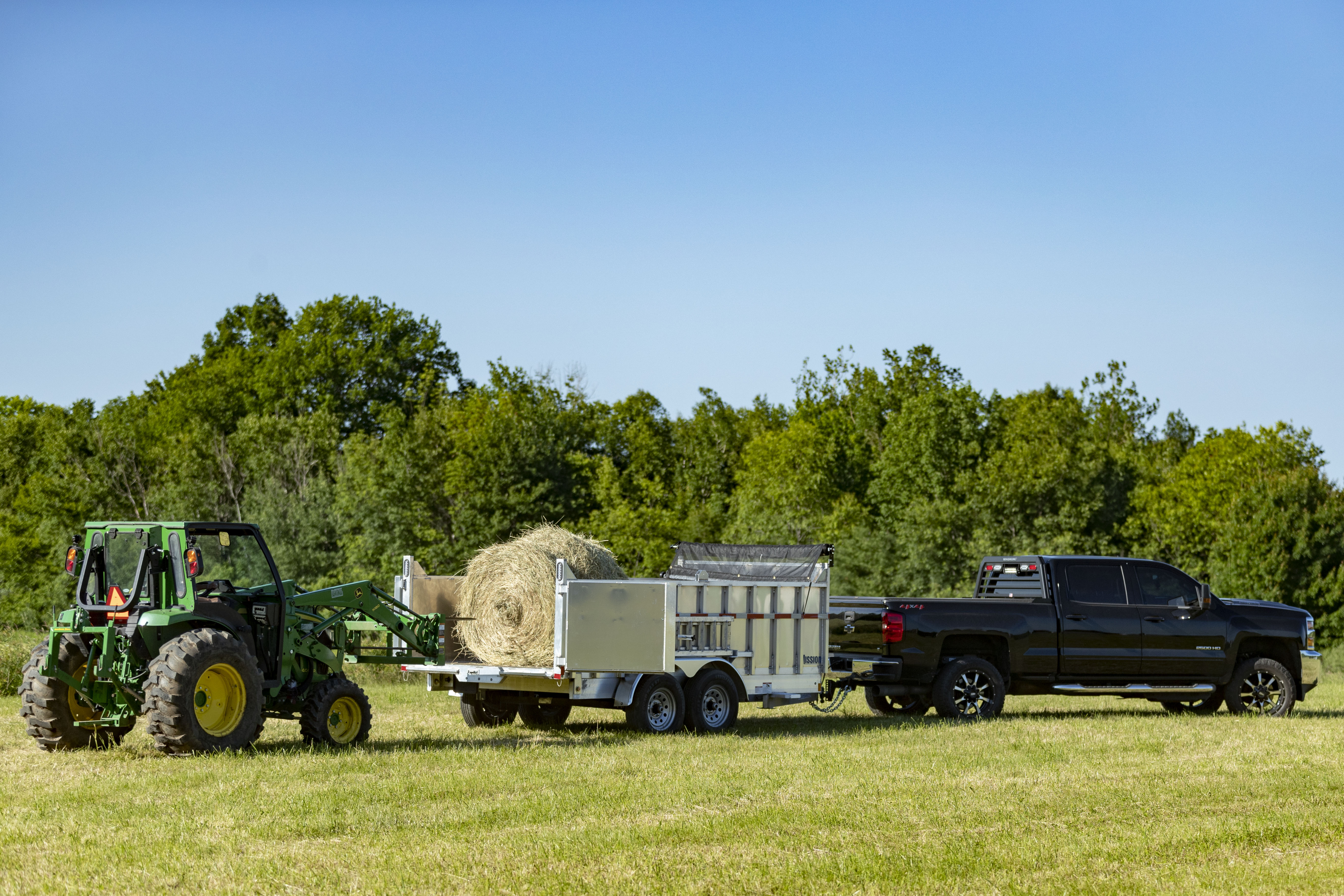Loading hay with a tractor into a Mission aluminum dump trailer
