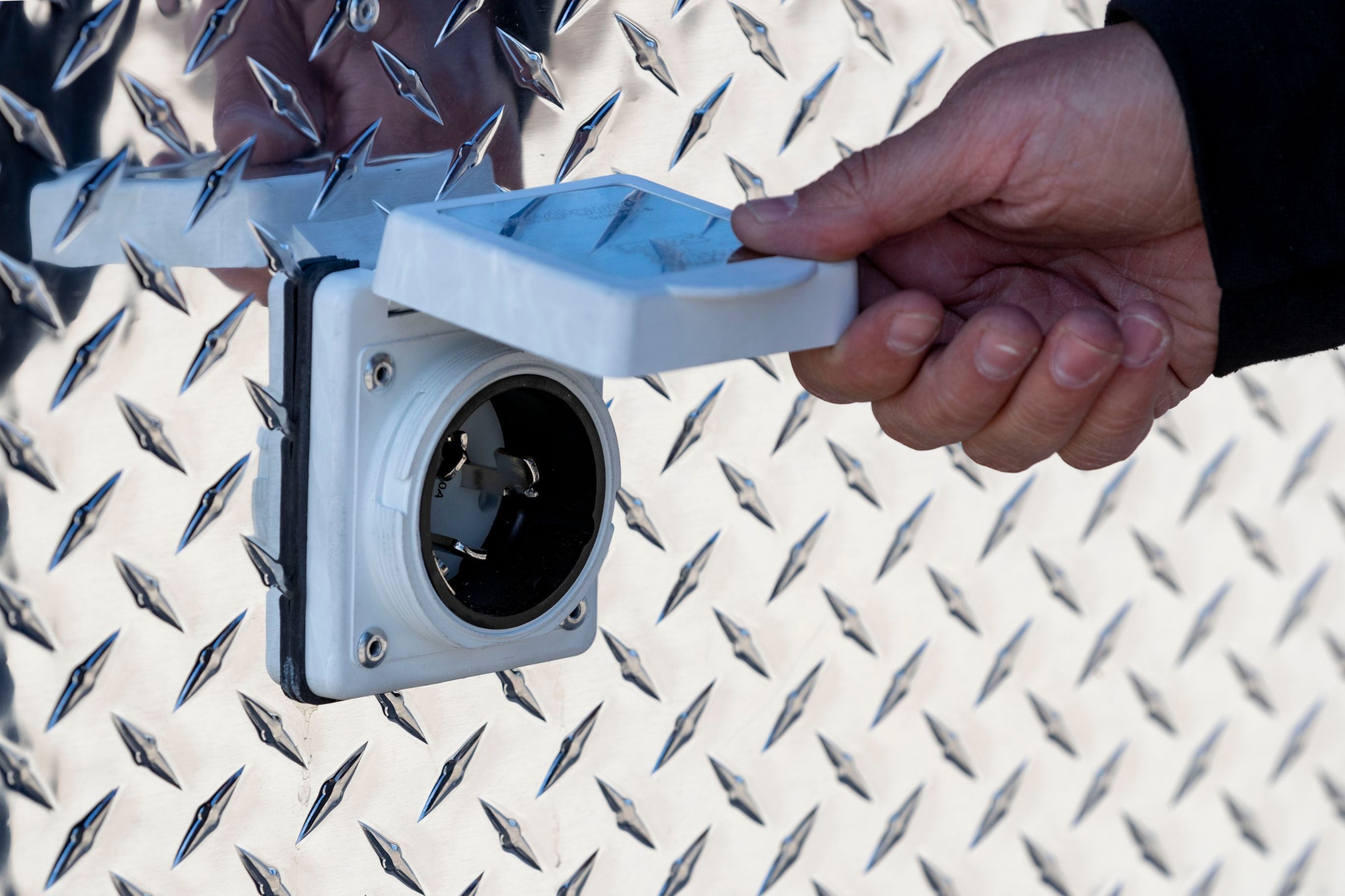 Motor base plug on the exterior of an ALCOM aluminum enclosed trailer
