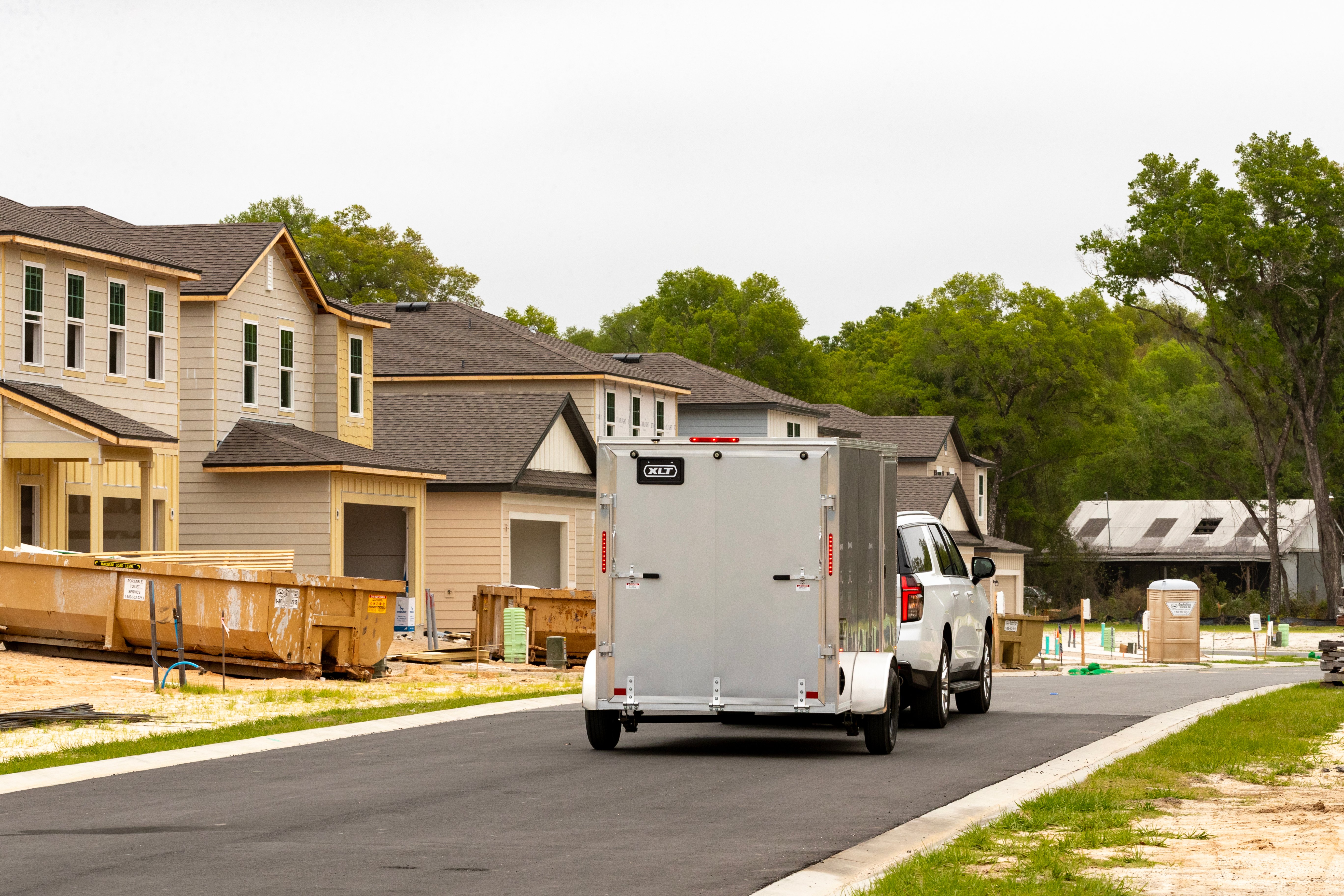 XLT enclosed aluminum cargo trailer towed through a construction area