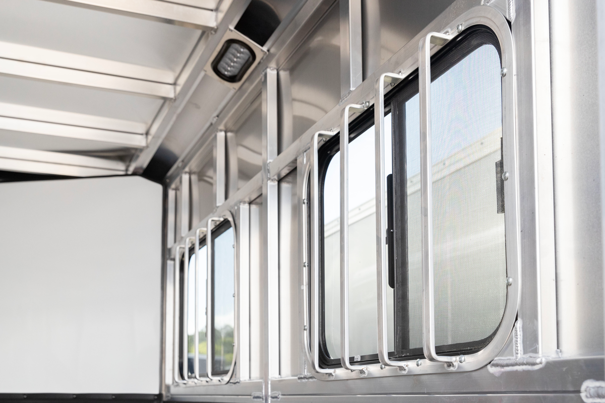 Sliding window and screen inside an aluminum livestock trailer