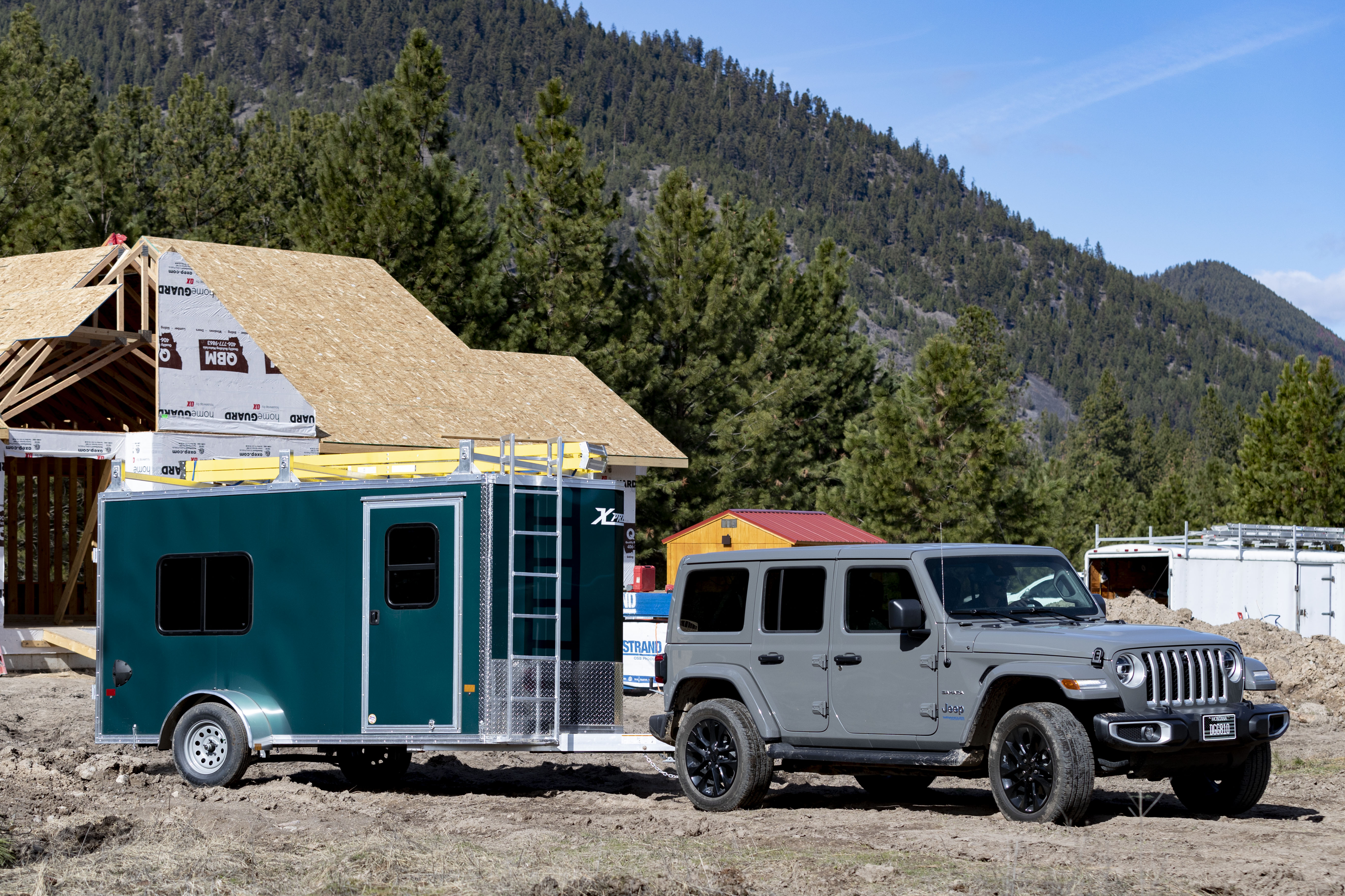 An enclosed contractor package with ladder racks parked at a residential jobsite